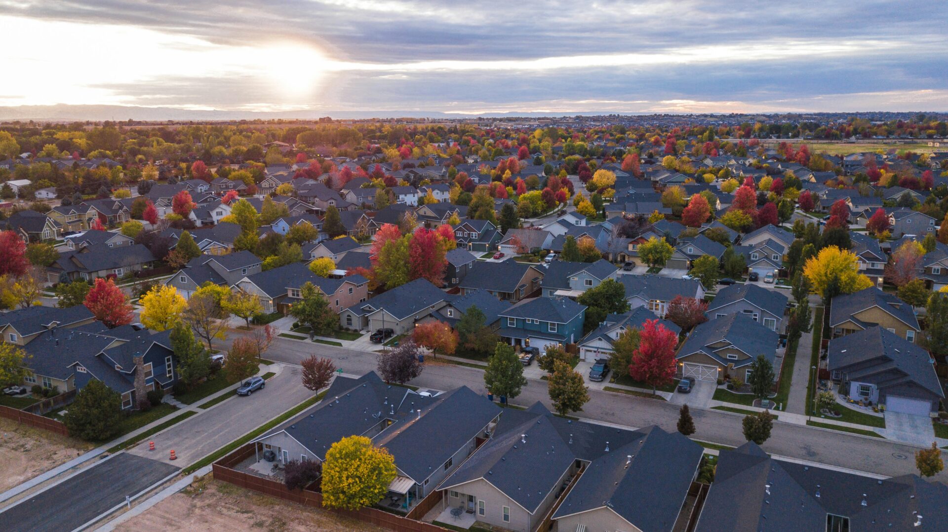 A view of houses with autumn trees in the background.
